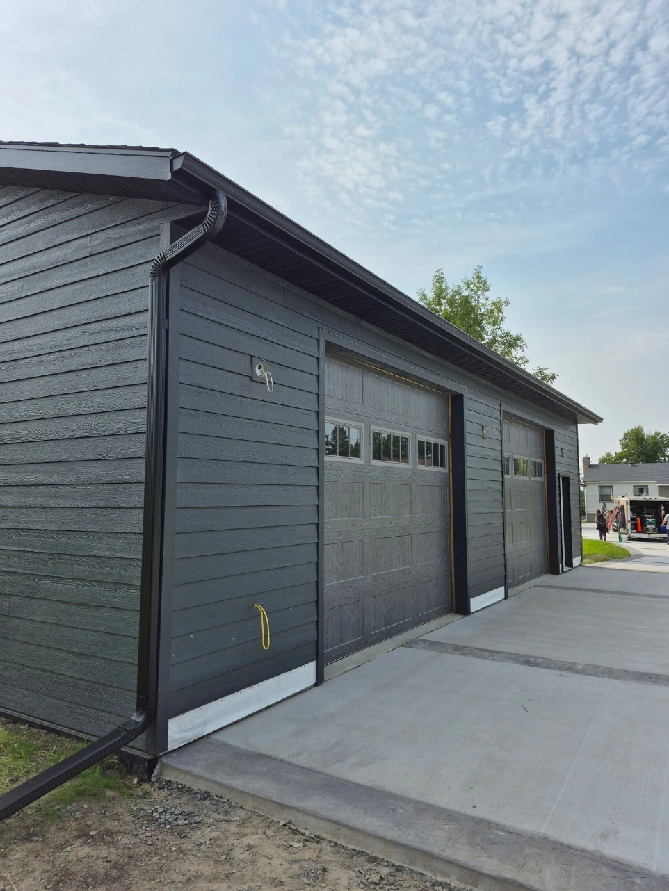 Gutter installation on garage with downspouts in International Falls
