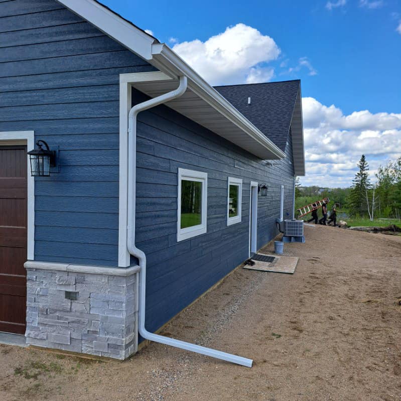 New seamless gutters installed on blue house in International Falls